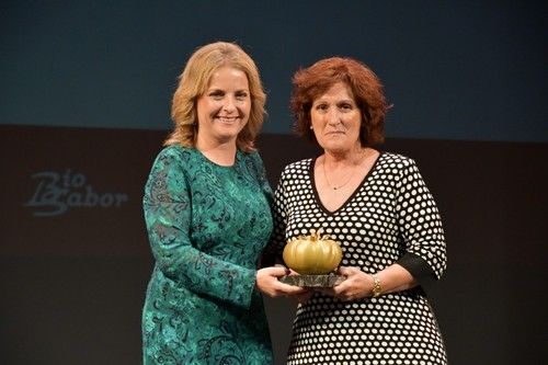 La diputada de Promoción Agroalimentaria, María Luisa Cruz, entrega el premio a Rosario, hermana de Víctor Manuel Puertas, el agricultor premiado.