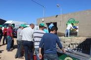 Agricultores esperando para probar suerte, en un juego de 'tiro al globo' con regalos.