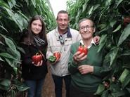 Un padre con sus dos hijos posando con pimientos Enol F1.
